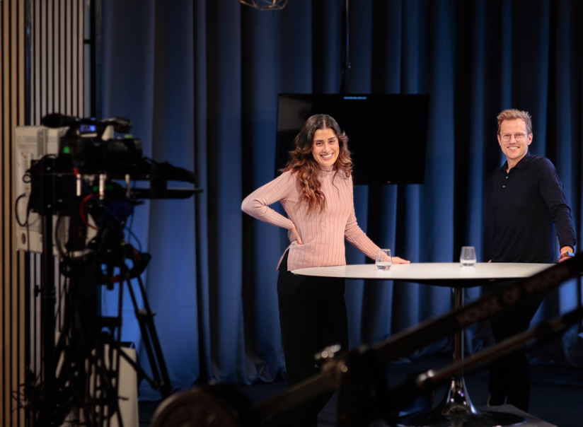 Inspelning av företagsfilm framför blå gardiner i studion